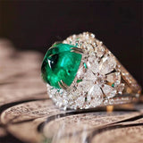 Retro ring with flowers, green stone, and diamonds