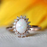 Vintage rose gold ring with oval opal and radiant crystal border